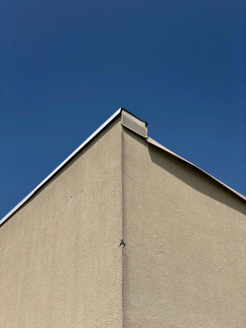 a corner of a building with a blue sky in the background