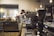 A barista skillfully preparing coffee in a cozy coffee shop setting.