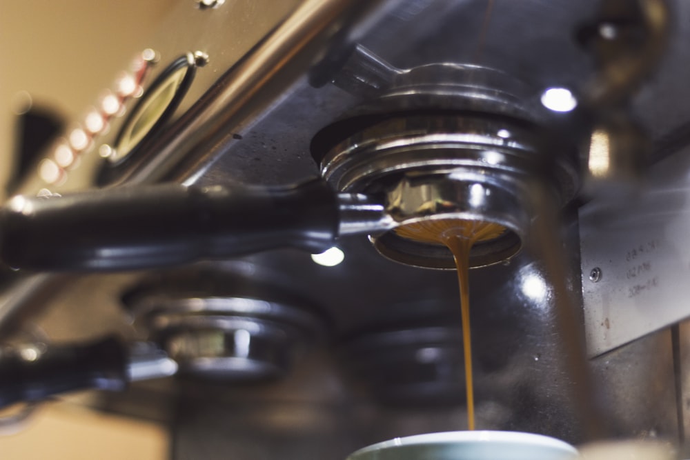 a coffee maker pouring coffee into a cup