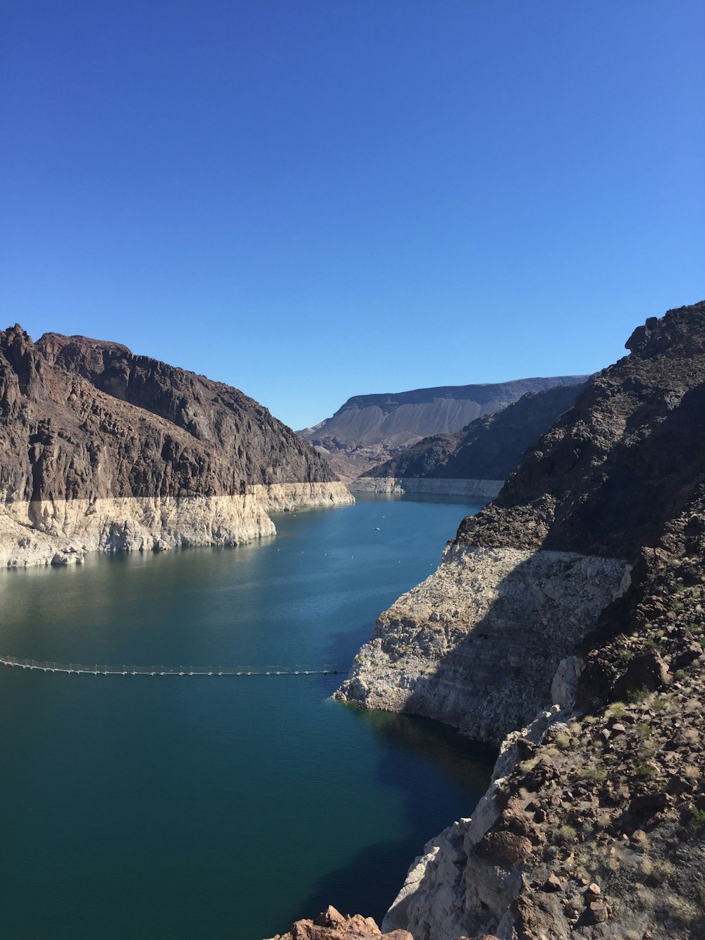 body of water between mountain during daytime