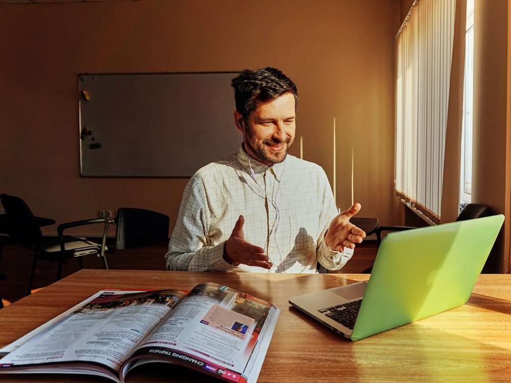 smiling man facing laptop