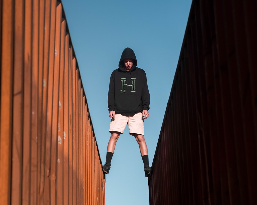 man standing between two shipping containers