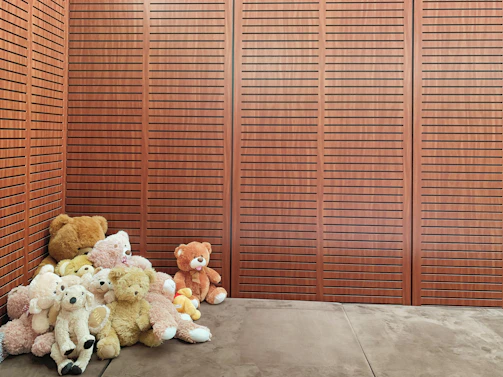 A cozy corner filled with soft teddy bears in various colors and sizes, inviting a warm hug.