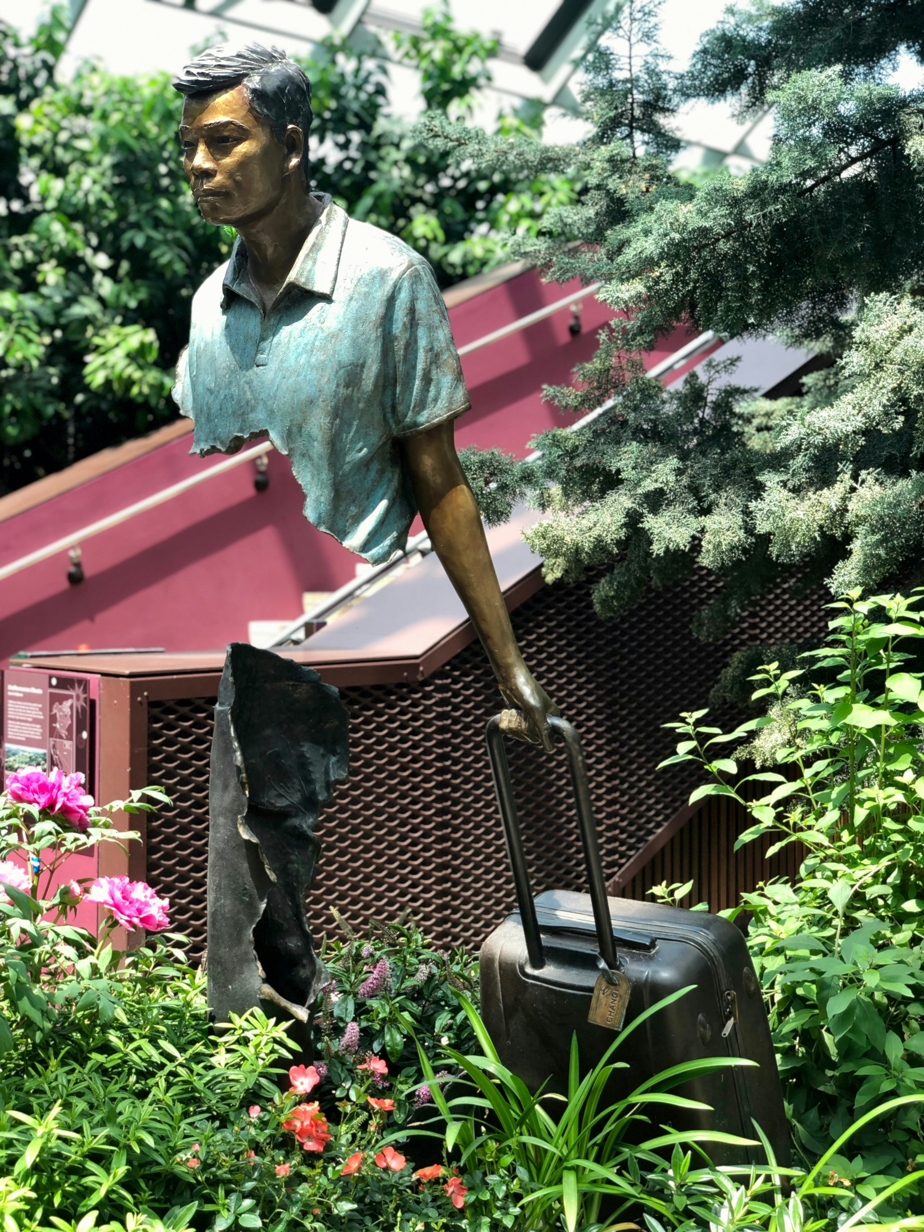 man pulling luggage statue