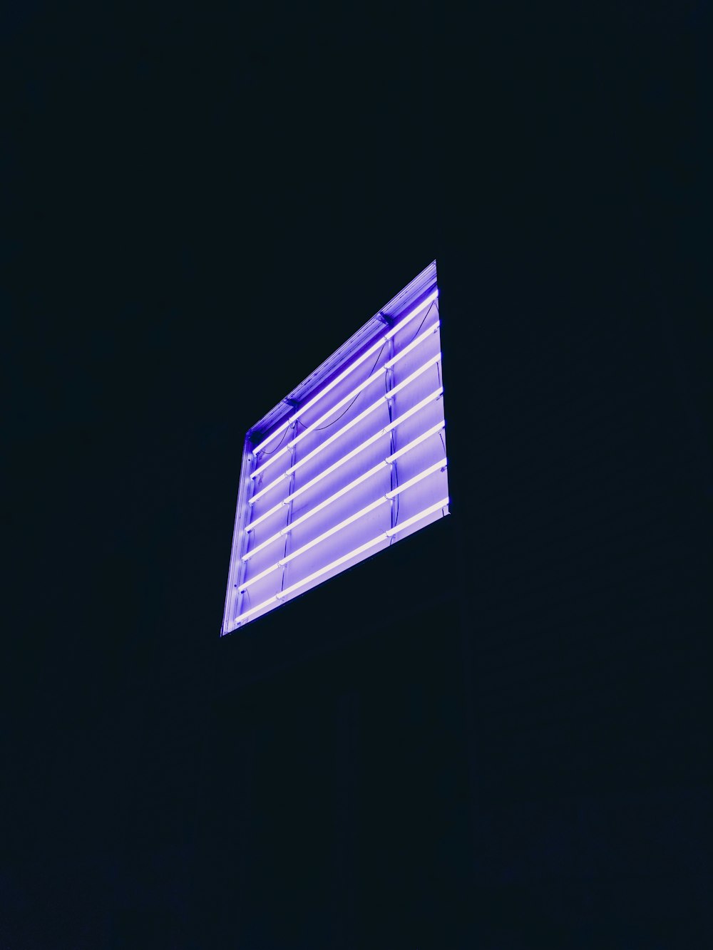 a window with blinds lit up in the dark