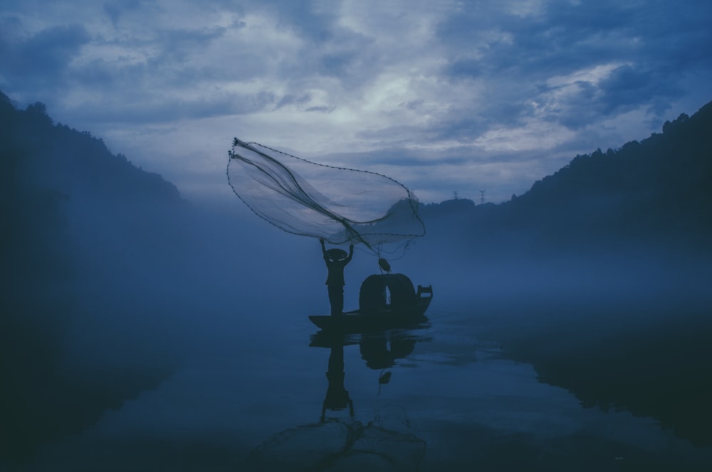 Person, die nachts in einem Gewässer fischt
