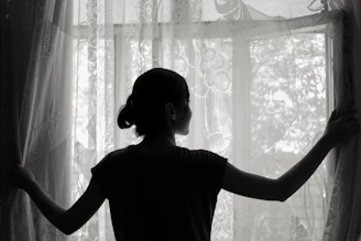 silhouette of woman opening window