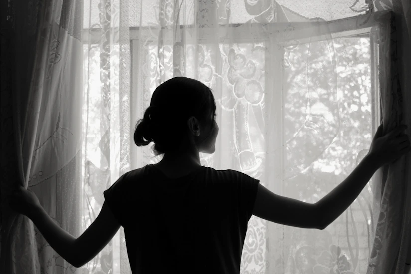 silhouette of woman opening window