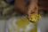 Man holding a sealed pouch of cooked rice with a bright kitchen background.