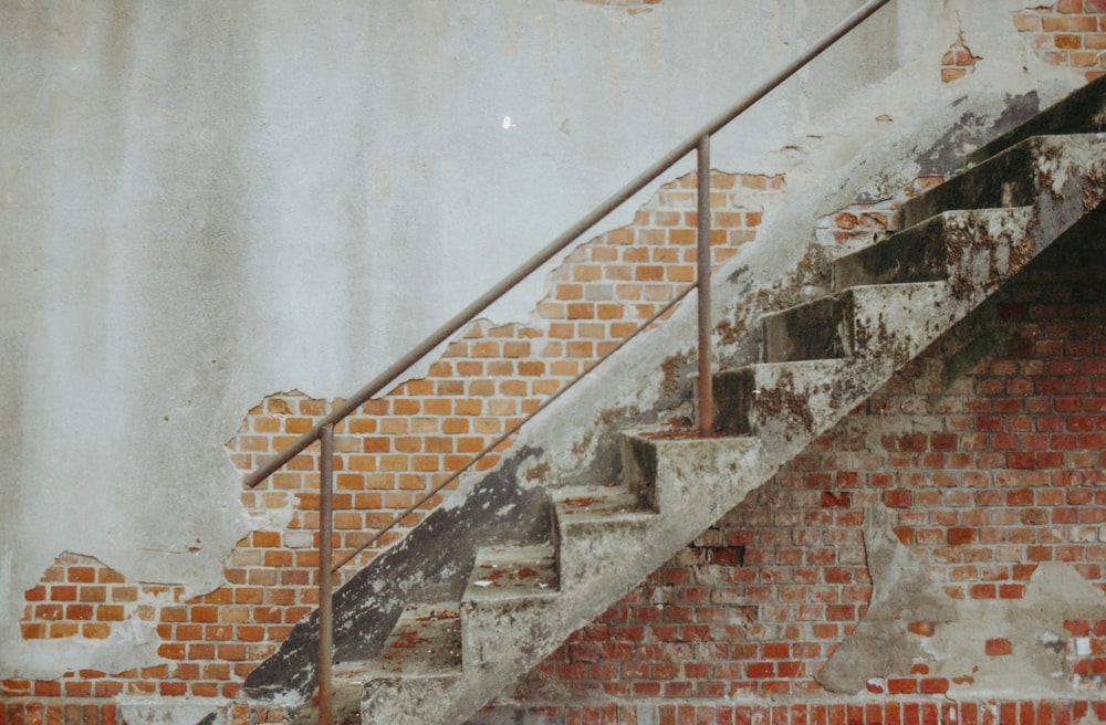 empty stairs near red brick wall