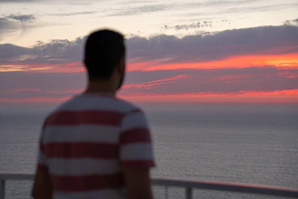 Pessoa refletindo profundamente enquanto observa o horizonte em momento de introspecção