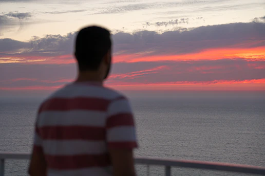 Pessoa refletindo profundamente enquanto observa o horizonte em momento de introspecção