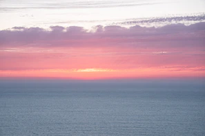 Sunset hues blending into a calm sea horizon.