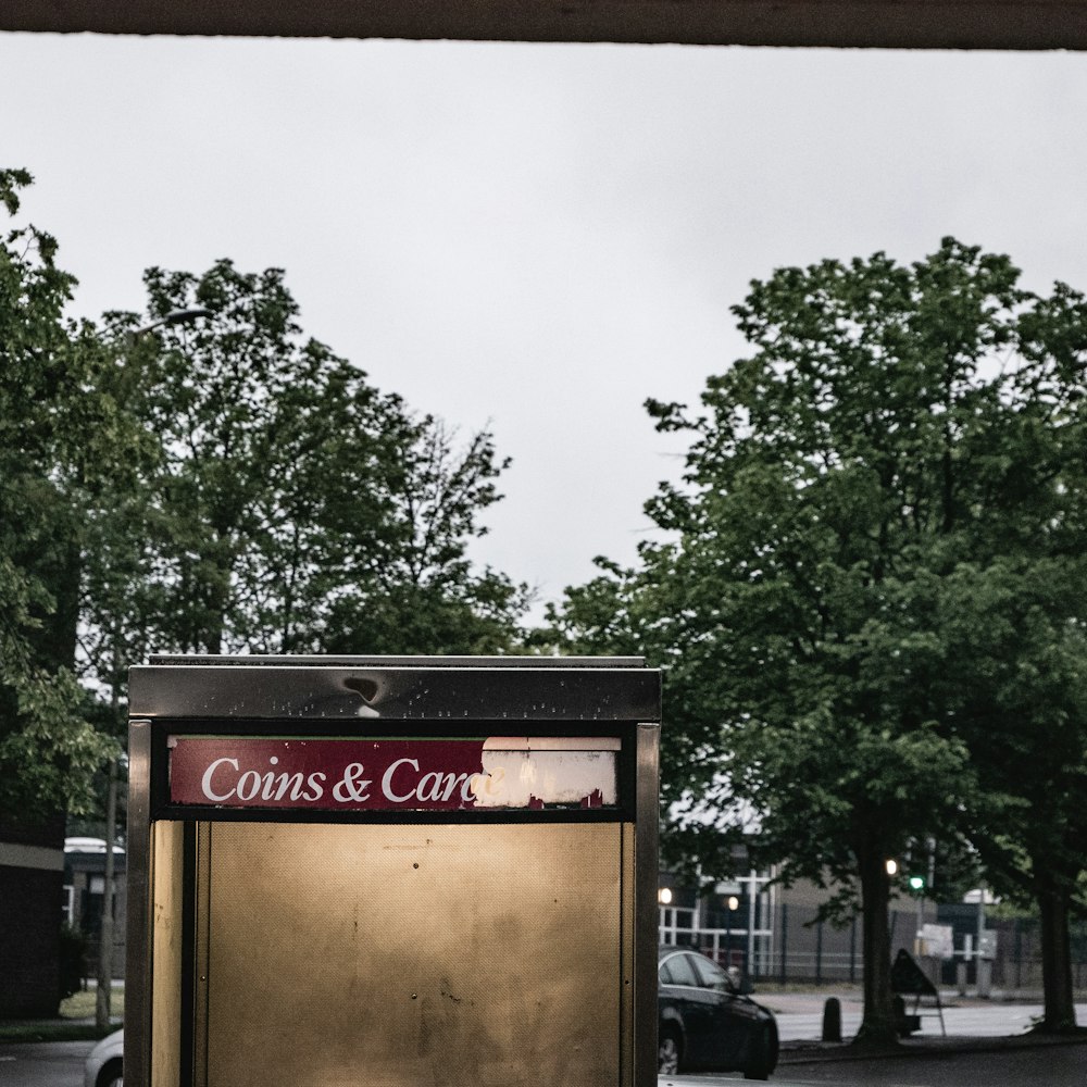 a coin machine sitting on the side of a road