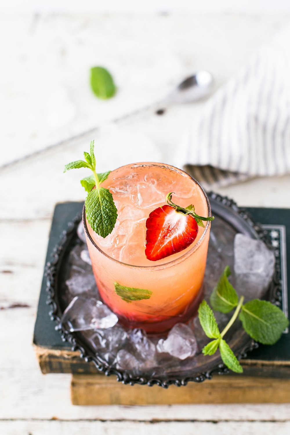 clear glass cup with red beverage and strawberries