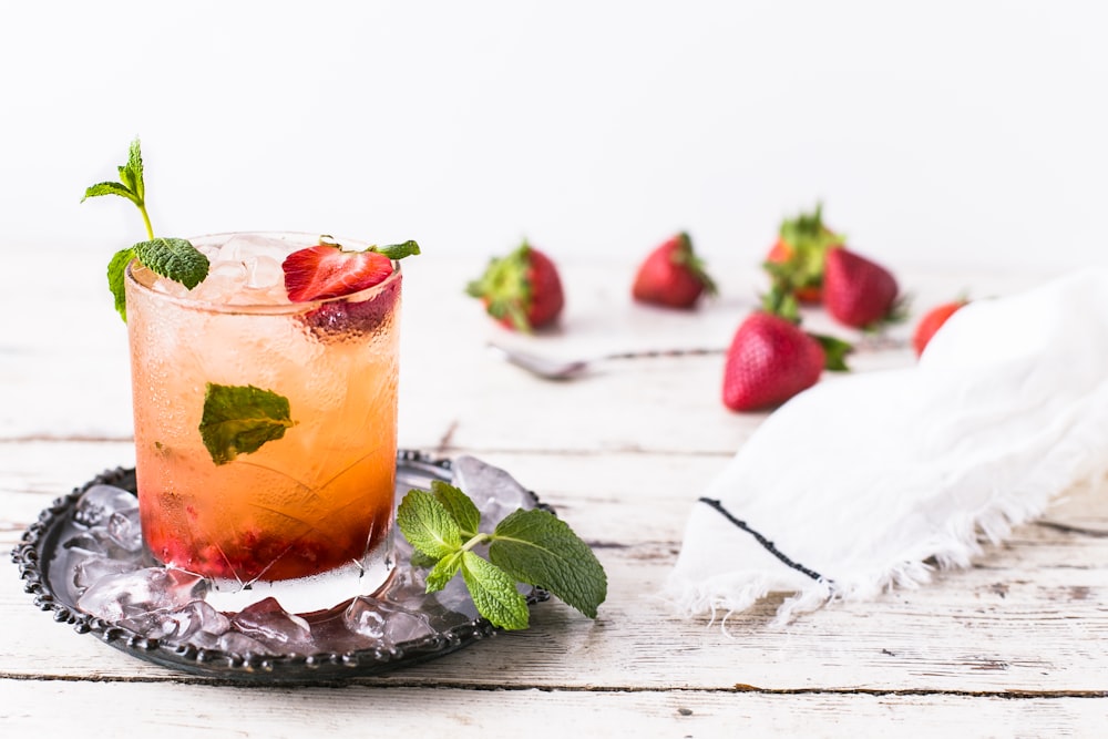 verre de boisson à la menthe et à la fraise sur panneau brun