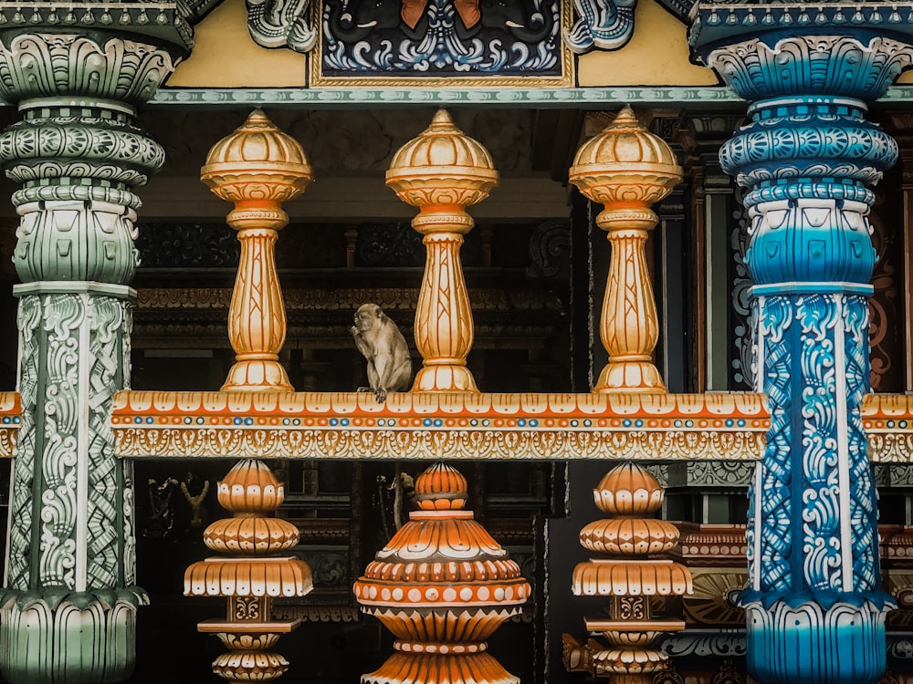 brown and gray monkey near multicolored balusters