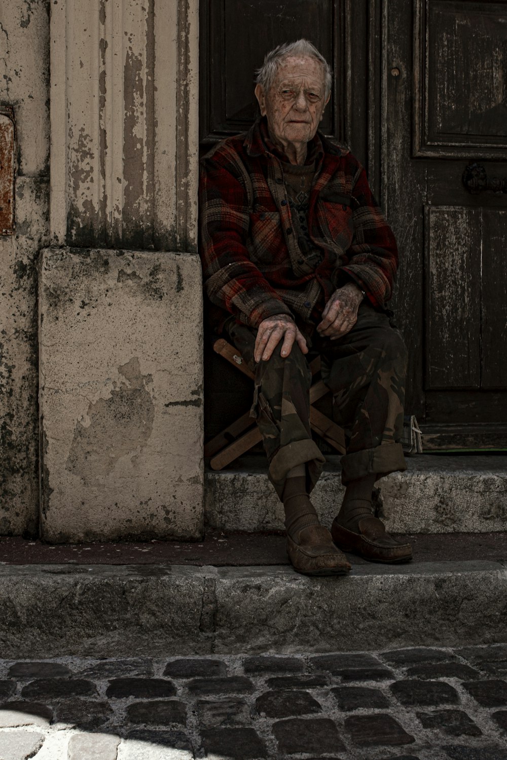 man sitting on folding chair beside door