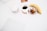 A minimalist setup with a white table featuring a banana, a cup of black coffee, a small plate with cookies, and a white electronic device. The ambiance is clean and organized, with a focus on simplicity.