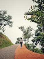A person walking along a simple path in nature, reflecting on spiritual growth.