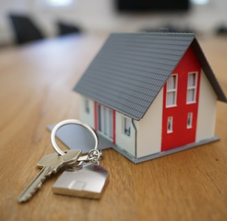 white and red wooden house miniature on brown table