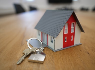 white and red wooden house miniature on brown table