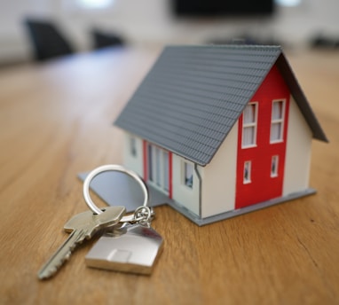 white and red wooden house miniature on brown table