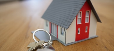 white and red wooden house miniature on brown table