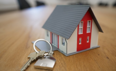 white and red wooden house miniature on brown table