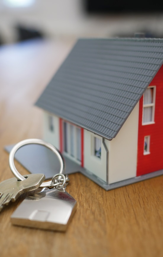 white and red wooden house miniature on brown table