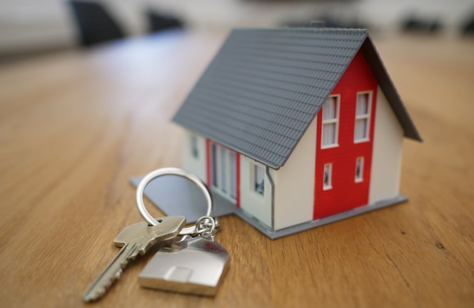 white and red wooden house miniature on brown table