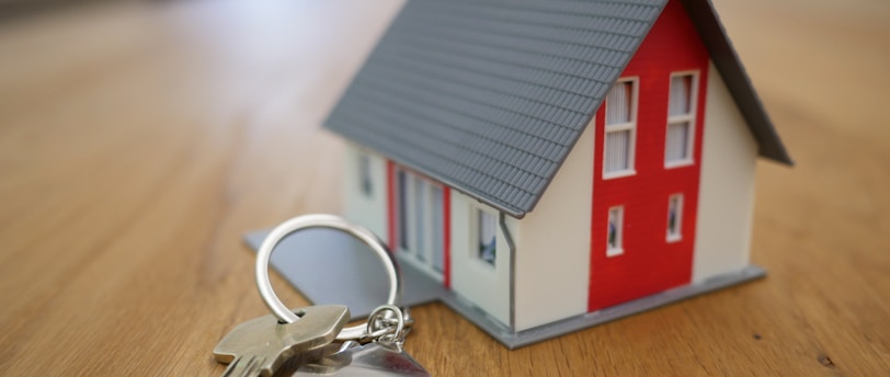 white and red wooden house miniature on brown table