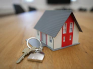 white and red wooden house miniature on brown table