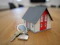 white and red wooden house miniature on brown table