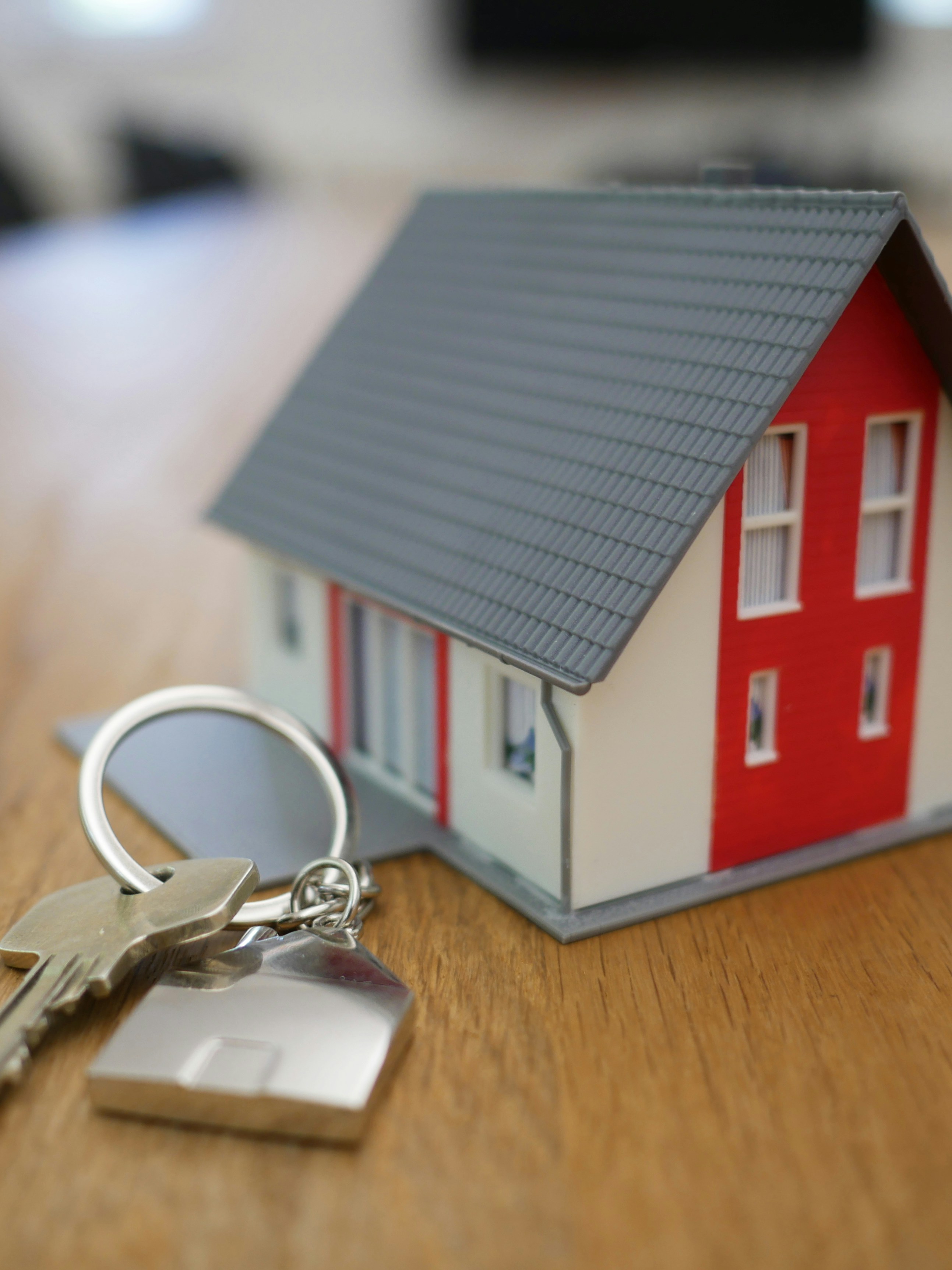 white and red wooden house miniature on brown table