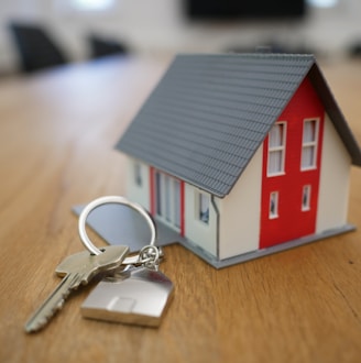 white and red wooden house miniature on brown table