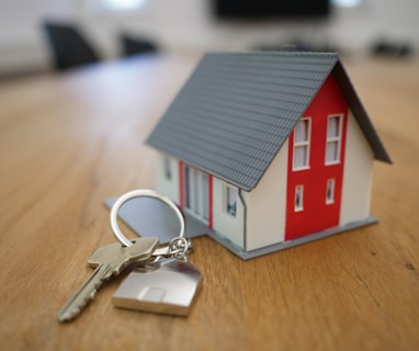 white and red wooden house miniature on brown table