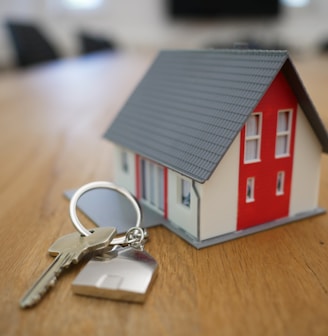 white and red wooden house miniature on brown table