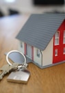 white and red wooden house miniature on brown table