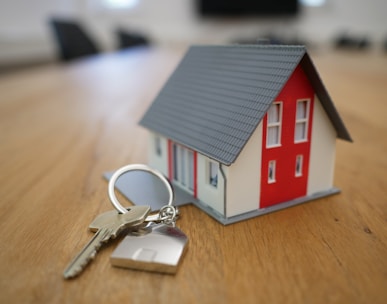 white and red wooden house miniature on brown table