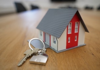 white and red wooden house miniature on brown table