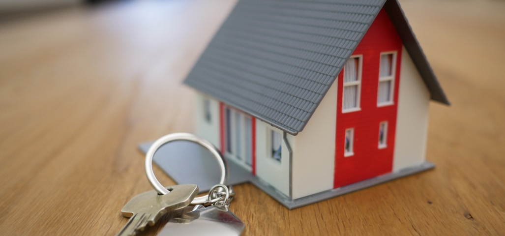 white and red wooden house miniature on brown table