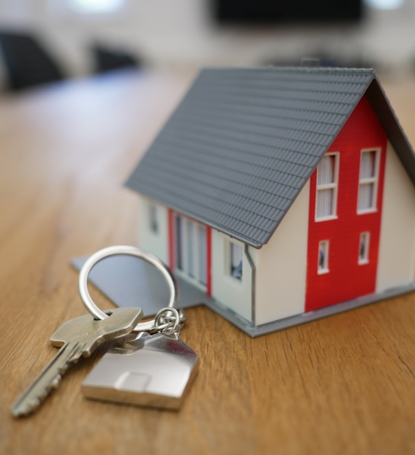 white and red wooden house miniature on brown table