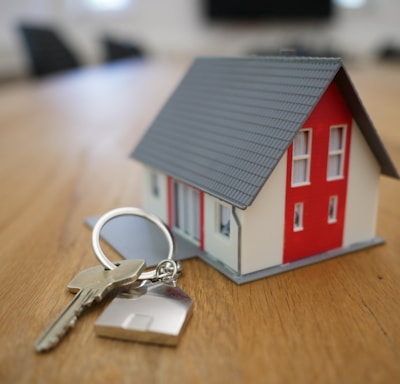 white and red wooden house miniature on brown table