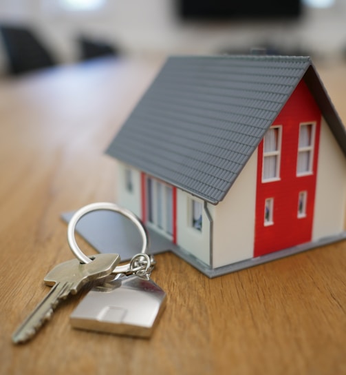 white and red wooden house miniature on brown table