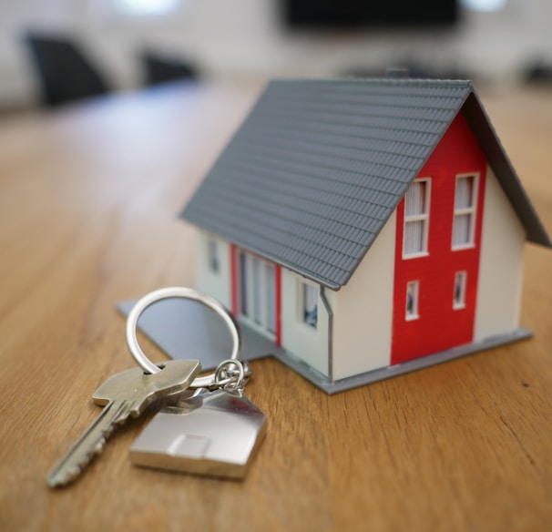 white and red wooden house miniature on brown table