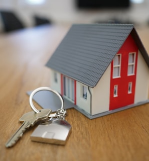 white and red wooden house miniature on brown table