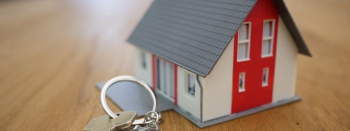 white and red wooden house miniature on brown table