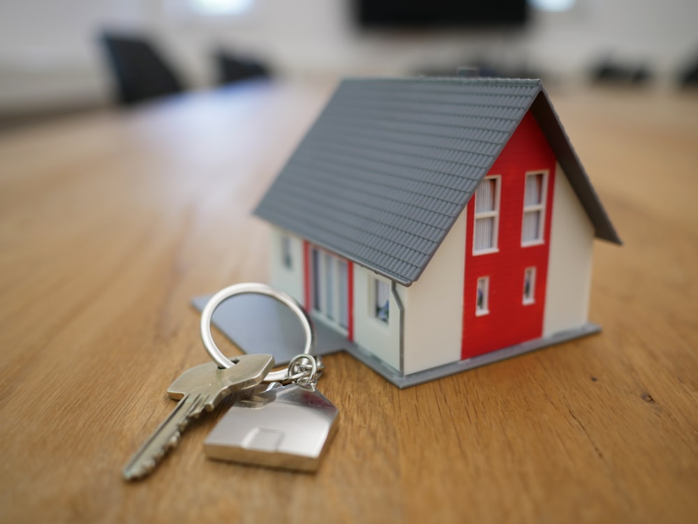 Miniatura de la casa de madera blanca y roja sobre mesa marrón