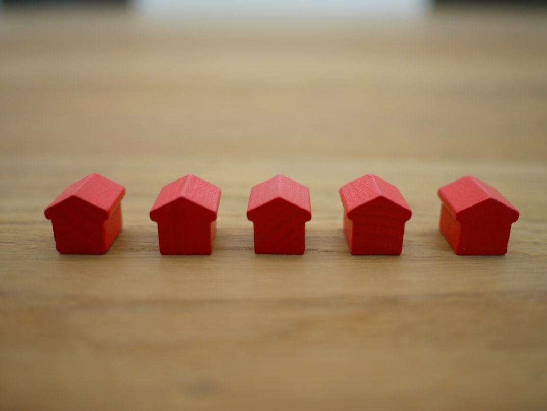 Five small wooden houses painted red.